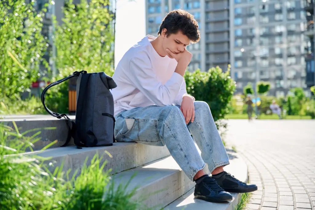 college student sitting alone, struggling with stress and substance use
