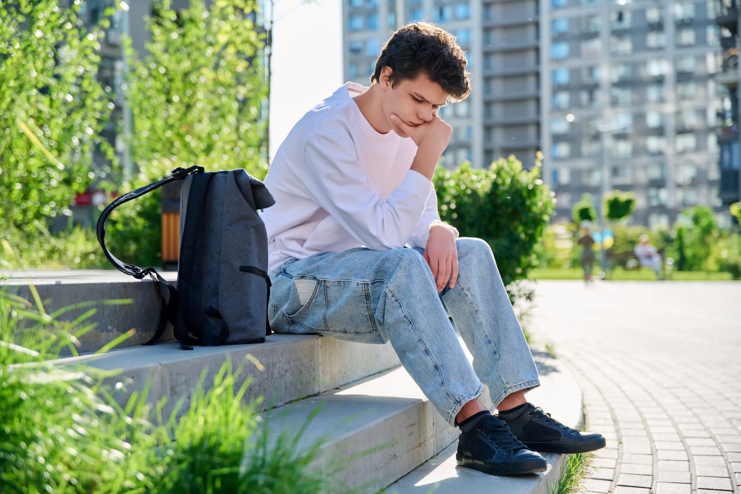 college student sitting alone, struggling with stress and substance use