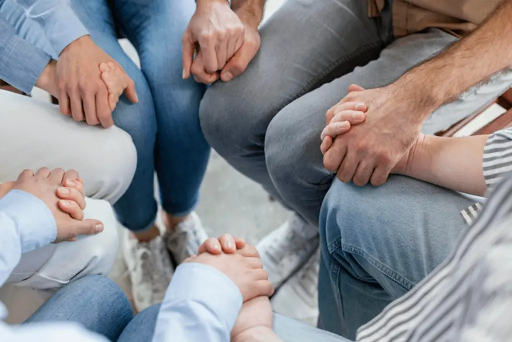 Family holding hands during group therapy.