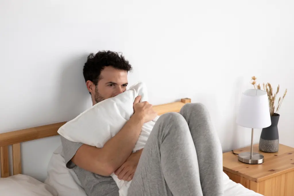 A worried man sitting in bed