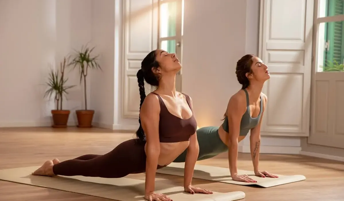 Two women practising yoga as a part of a holistic therapy for addiction treatment.