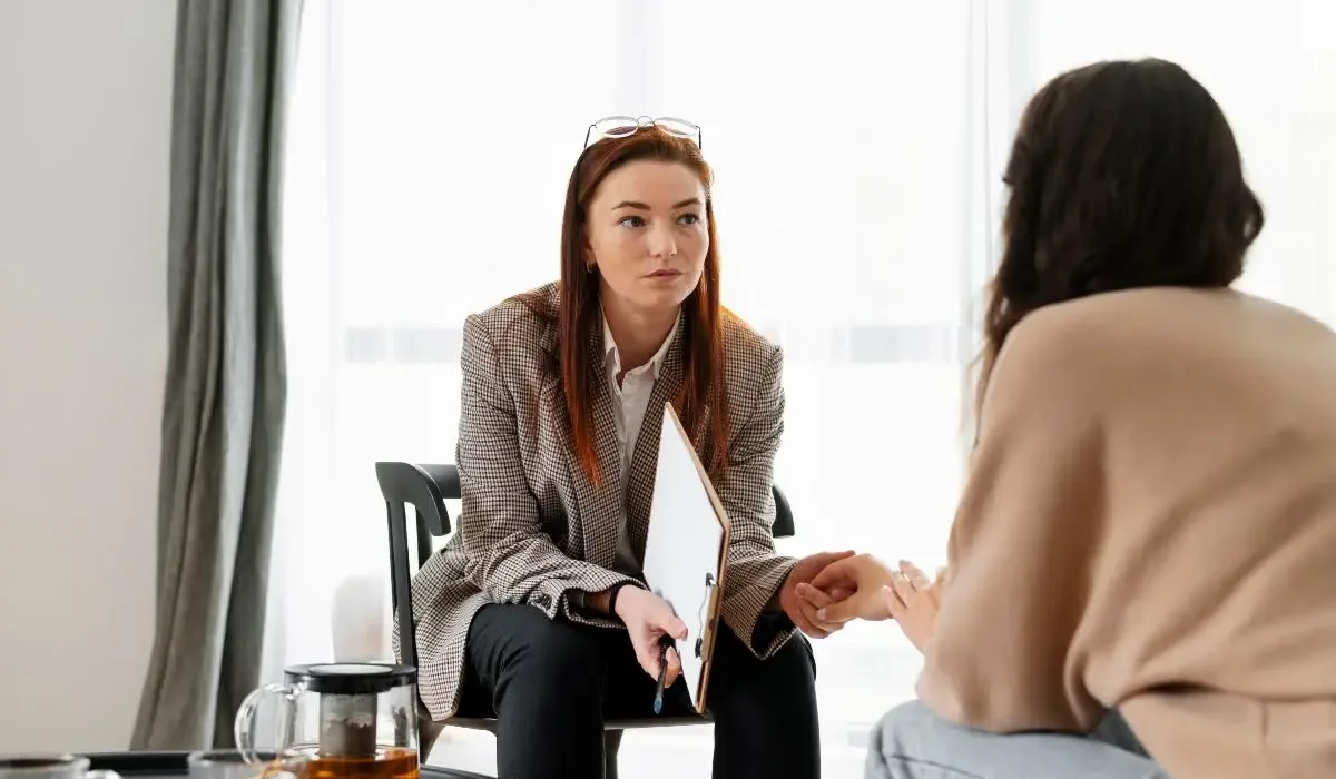 Therapist explaining to a patient the difference between luxury treatment and standard rehab programs.